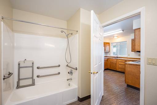 A white bathroom with a walk in shower and a white tub.