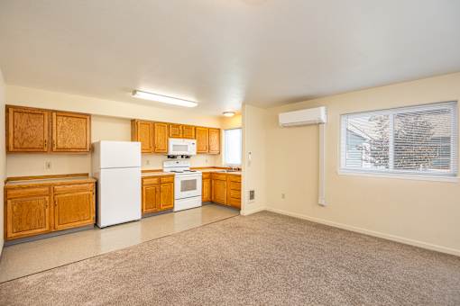 A kitchen with white appliances and wooden cabinets.