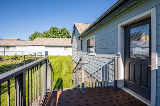 A house with a grey exterior and a brown deck.