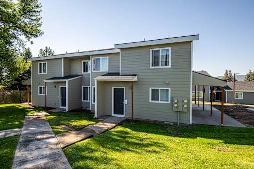 A modern two-story house with a grey exterior and a small front yard.