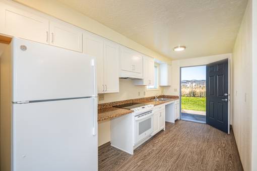 A kitchen with white appliances and cabinets.