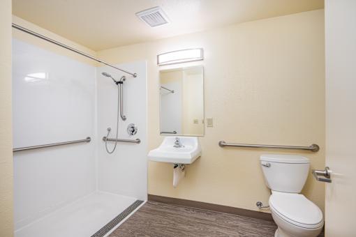 A white toilet sits next to a sink in a bathroom.