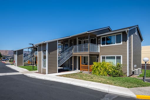 A modern two-story house with a balcony and stairs leading to the second floor.