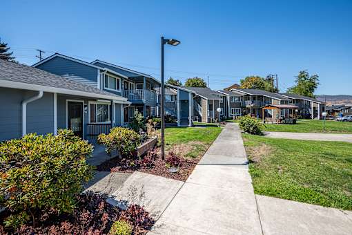 A row of houses with a sidewalk in front.