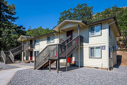 A two-story house with a red door and a balcony.