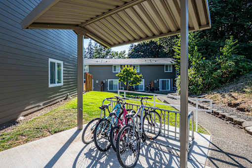 A bicycle is parked under a covered area.