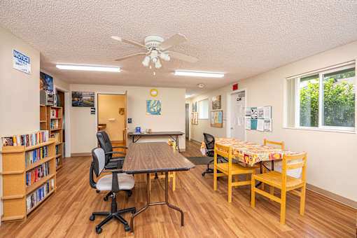 a classroom with desks and chairs in a room with windows