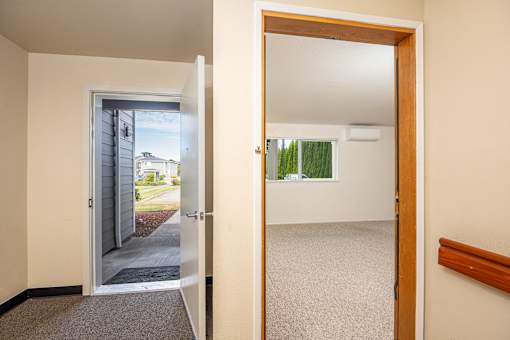 A room with a carpeted floor and a wooden door.