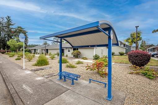 a blue bench sitting under a covered park pavilion
