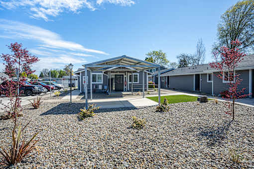 A building with a gravel driveway in front of it.