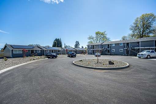 A parking lot with cars and apartment buildings in the background.