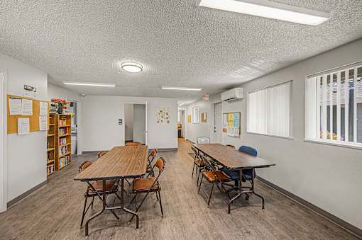 A room with a long table and chairs.