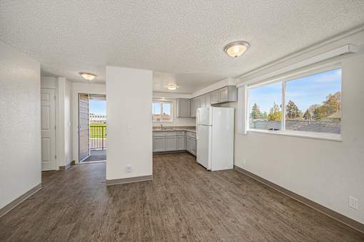 A kitchen with white appliances and wood floors.