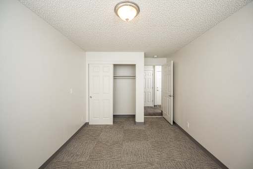 A room with a carpeted floor and a white door.