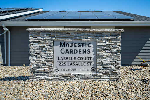 Majestic Gardens sign in front of a house with solar panels.