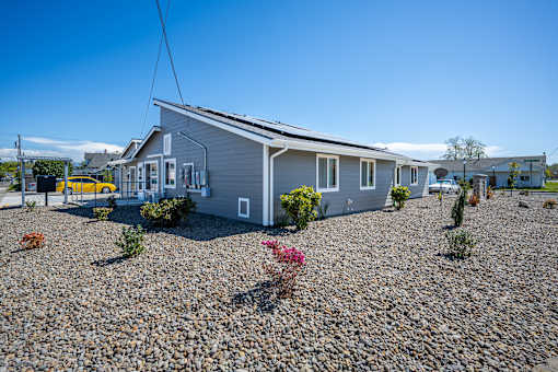 A house with a grey roof and a yellow car parked in front.