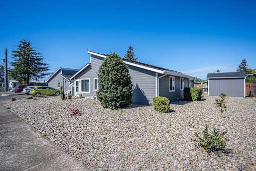 A house with a grey roof and a green car parked in front.