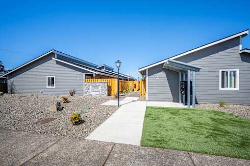 A building with a grey exterior and a yellow door.
