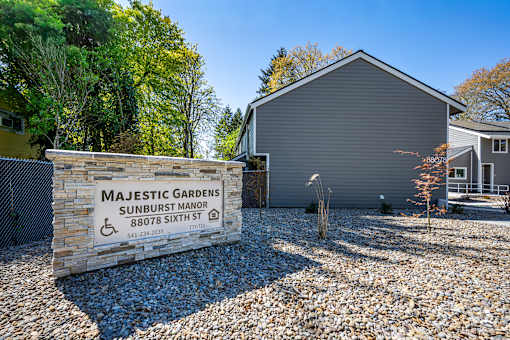 Majestic Gardens Sunburst Manor is a residential building with a sign in front.