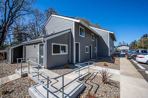 A grey house with a metal ramp in front.