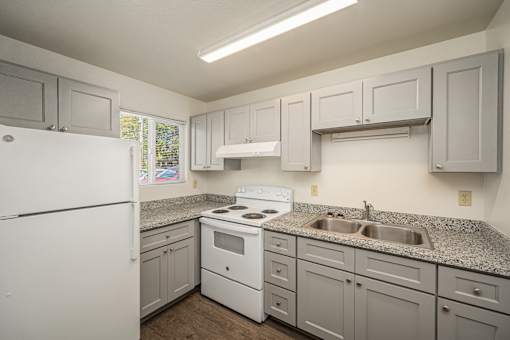 A kitchen with white appliances and cabinets.