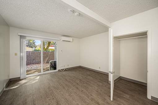 A room with a sliding glass door leading to a backyard.