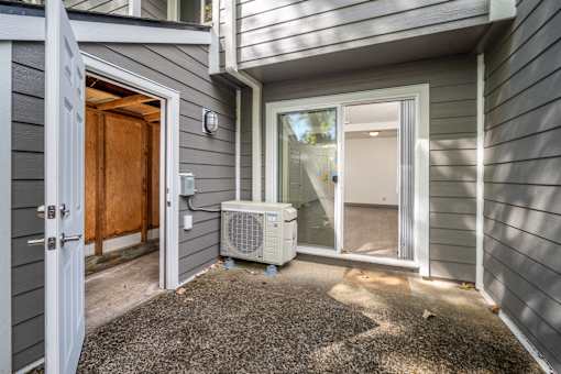 A grey house with a brown door and a window.
