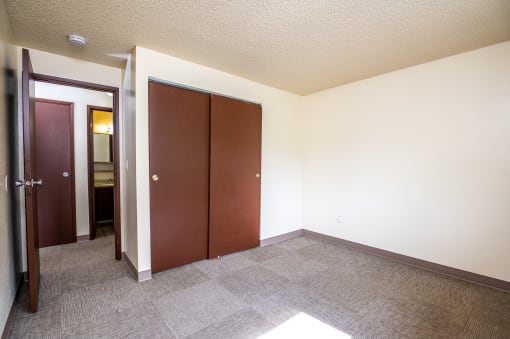 an empty room with two doors and a carpeted floor