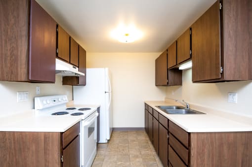a kitchen with wooden cabinets and white appliances