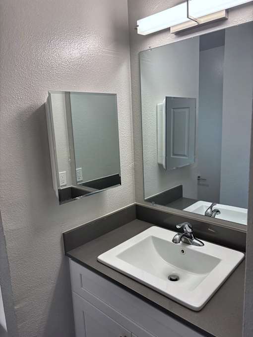 A bathroom with a sink and mirror.