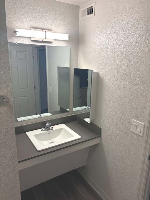 A bathroom with a sink and mirror.