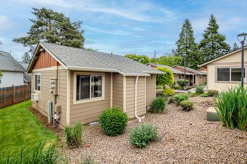 A house with a brown roof and a gravel yard.