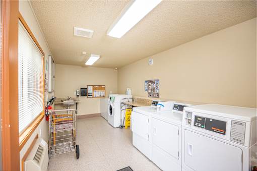 A laundry room with a washer and dryer, a microwave, and a small refrigerator.