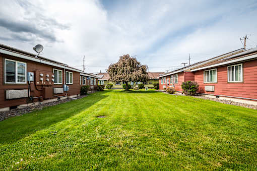 A row of houses with a green lawn in the foreground.