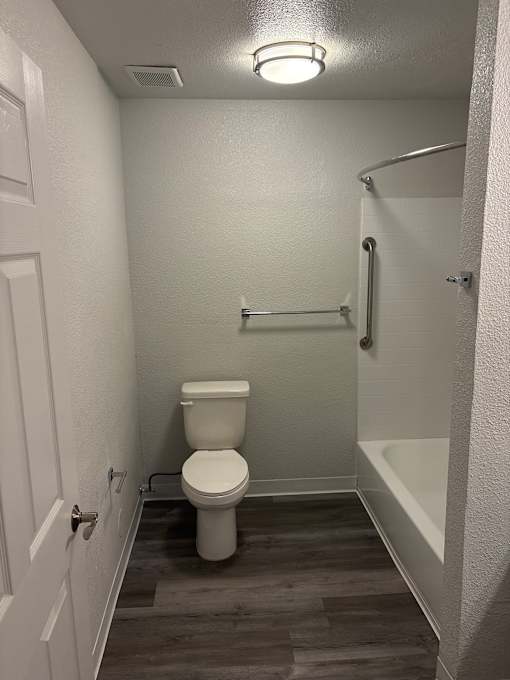 A white bathroom with a toilet, sink, and mirror.