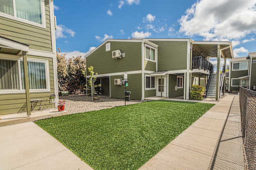 a view of a yard in front of two apartment buildings