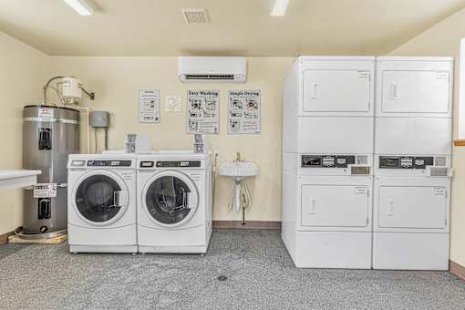 a laundry room with washer and dryers and a sink
