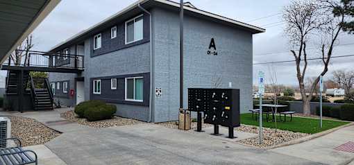 A grey building with a black sign on the front.