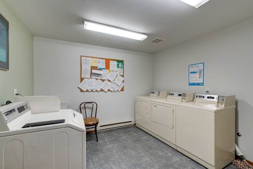 a laundry room with washers and dryers and a poster on the wall