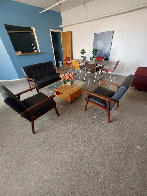 A living room with a black sofa, a coffee table, and a chair.