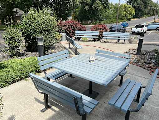 a picnic table and benches on a sidewalk