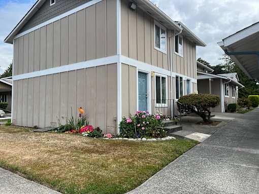 A house with a grey siding and a blue door.