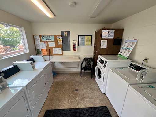 A laundry room with a washer and dryer, a sink, and a bulletin board.