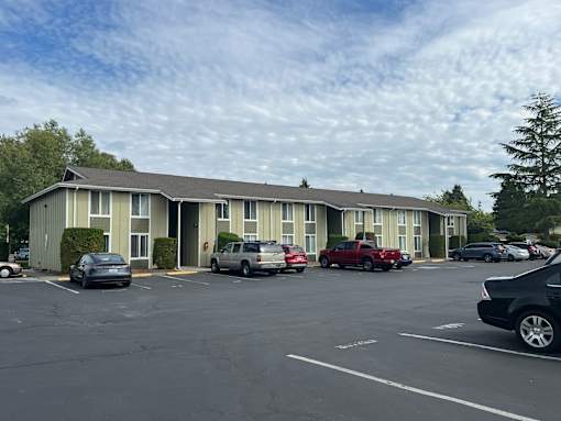A parking lot with cars and a building in the background.