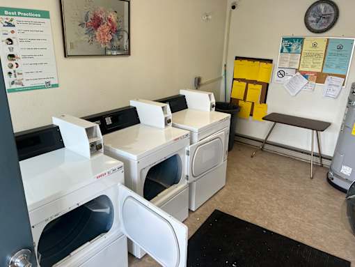 A laundromat with washers and dryers and a sign that says Best Practices.