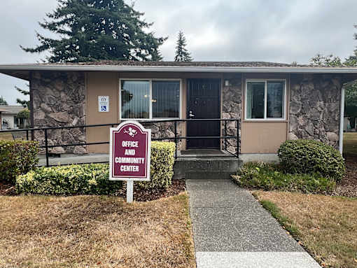 A sign in front of a building that says Office and Community Center.