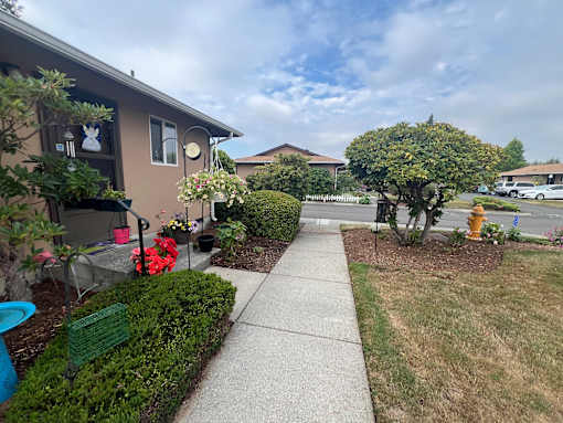 A residential area with a house, a sidewalk, and a fire hydrant.