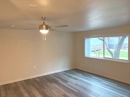 A room with a ceiling fan and a window.