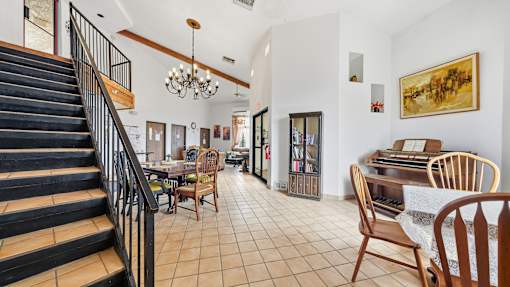 A living room with a staircase and a dining table.