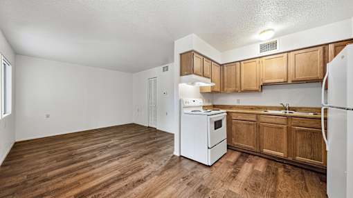 A kitchen with wooden cabinets and a white refrigerator.